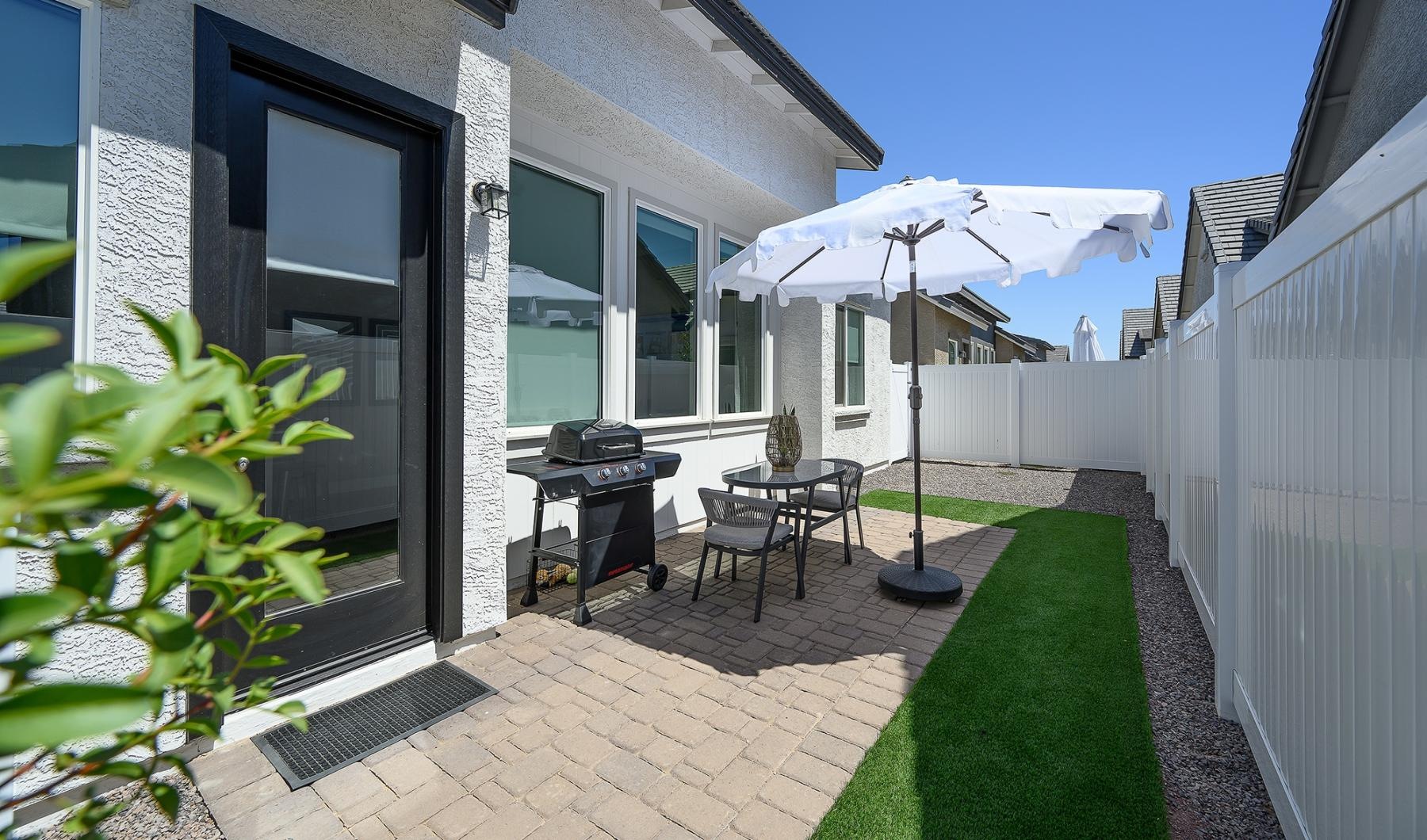 a patio with a table and chairs and umbrellas